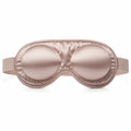Black mulberry silk sleep eye mask on white bedding for restful beauty sleep